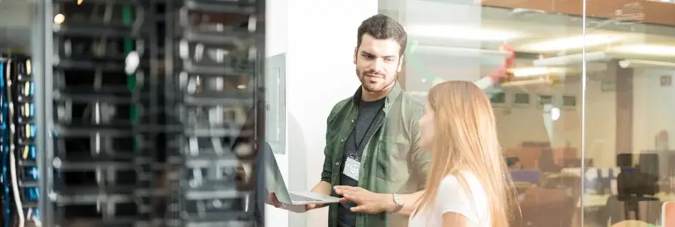 IT Security professional talking to businessperson while standing in server room