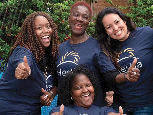 A groupd of women wearing Hestia t-shirts standing together smiling at the camera