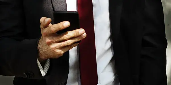 Businessman viewing a mobile device in right hand