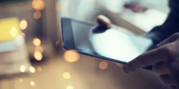 Close up of person using a digital tablet device against defocused background
